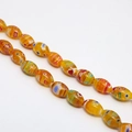 Macro detail of oval millefiori glass beads with vibrant floral patterns for DIY jewelry - Approx. 32 Pcs/Strand (8x13mm) / Orange