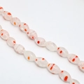 Close-up of oval millefiori glass beads with orange floral patterns for DIY jewelry - Approx. 32 Pcs/Strand (8x13mm) / Red White