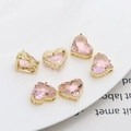 Macro shot of six pink heart zircon charms with gold-plated settings for DIY jewelry - Light Pink