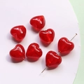 Macro view of glossy red glass heart-shaped beads for DIY jewelry and crafts - Red
