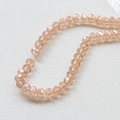 Macro shot of 4mm faceted champagne crystal glass beads on a white leather surface - Pink (16#)