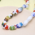 Macro detail of multi-colored millefiori floral faceted glass beads for DIY jewelry - Multifaceted (White) (1 Strand)