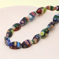 Macro shot of colorful millefiori glass oval beads with floral patterns for DIY jewelry - Teardrop Shape (Black Multicolor) (1 Strand)