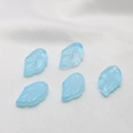 Macro view of light blue translucent glass leaf charms with detailed vein texture - Blue