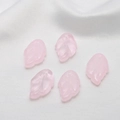 Macro shot of five frosted pink glass leaf charms with holes on white silk background - Light Pink