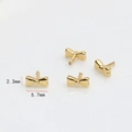 Macro detail of tiny gold-plated bow charm with 2.3mm by 5.7mm size measurements - Gold Bow Tie Style