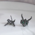 Detailed view of gunmetal dragon studs with green gemstone eyes and threaded earring backs - Gunmetal
