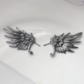 Detail view of gothic black feather wing earrings with intricate metallic texture - Gunmetal