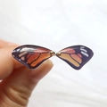 Detailed close-up of resin butterfly wing charms with vibrant orange and black patterns - Black Border Butterfly