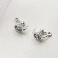 Vue macro de pendentifs théière en métal argenté pour création de bijoux DIY sur cuir blanc - Petite Théière Platine