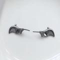 Macro view of gunmetal bat wing earrings with a polished finish for Gothic jewelry styles - Small Bat Wings / Gunmetal