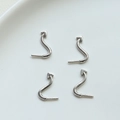Macro shot of 4-piece silver devil tail jewelry charms with polished S-curve on white ceramic - Silver Tail (2#)
