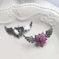Detail view of pink heart wing earrings with cubic zirconia on a white vintage plate - Rose Red (3#)