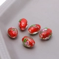 Macro detail of red glass oval beads with gold foil and embossed floral pattern - 1#Red