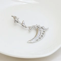 Macro detail of silver scythe pendant featuring intricate bone texture and zircon inlays - White Gold