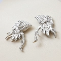 Close-up of silver-plated hollow carved flame earrings with zirconia on beige background - 2# Dragon Axe / White Gold