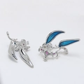 Detailed macro view of silver fantasy hollowed-out earring with blue enamel and red zircon - White Gold Style
