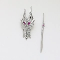 Macro detail of dragon head brooch and sword pin set with pink gemstones and silver finish - White Gold Mask And Sword / White Gold
