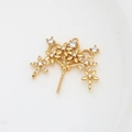 Detailed view of a gold-plated floral jewelry connector with shimmering cubic zirconia - Gold
