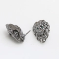 Detalle de pendientes de cabeza de león en acabado bronce con ojos de circón verde y cristales - Escudo de León Negro Pistola