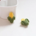 Makrodetail der handgefertigten Filz-Mais-Accessoires mit Textur und grünen Blättern - Mais / 1 Stück