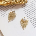Macro detail of golden fishtail dreamcatcher charms with faux pearls on vintage book - Firework Meteor Style (4#)