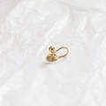 Macro di orecchino a clip a spirale placcato oro 14k su carta bianca testurizzata - 18k Con Perlina E Tappo Gomma