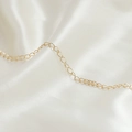 Macro di una catena a maglie placcata oro 14 carati su sfondo di raso bianco puro - Stile Ovale Continuo Dorato (9#)