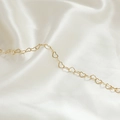 Dettaglio della catena a maglie a forma di cuore in oro 14k su sfondo di seta bianca - Stile Cuore Grande Dorato (6#)