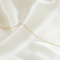 Vista macro di una sottile catena a maglie in oro 14k su sfondo di seta bianca - Stile Dorato Ultra Sottile (5#)