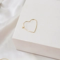 Vue détaillée d'une créole en forme de cœur plaqué or 14 carats sur support blanc - Forme de Coeur (18K)