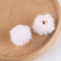 Detailed view of soft pink faux fur pompoms with metal loop on a wooden tray - 6# Light Pink