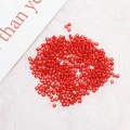 Macro shot of loose 2mm transparent red glass seed beads on a white textured background - 2 mm / Red (1#)