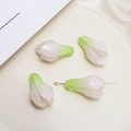 Macro detail of gradient pink and green magnolia bud pendants in a ceramic tray - Green Flower Bud