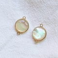 Détails macro de pendentifs ronds en nacre d'abalone dorés avec doubles anneaux - Petit Rond Double Boucle Coque Blanche