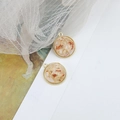 Macro view of vintage round gold alloy pendant with dried flowers for DIY jewelry making - Cream