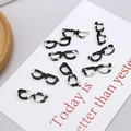 Macro detail of 8 marble-patterned eyeglass pendants for DIY jewelry making - Black and White Marble Glasses Style