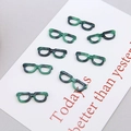Close-up of eight tortoiseshell resin eyeglass-shaped DIY charms for earring making - Green Glasses Style