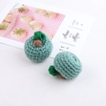 Detail of a handmade crochet green fruit pendant with a wool knit texture and leaf - Haze Blue