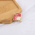 Macro view of Chinese fan pendant with red enamel, gold flower pattern and dual rings - Red Marble