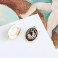 Macro view of vintage oval pendants with gold textured edges and black resin inlay - Black