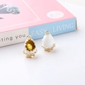 Detail showing gold alloy chicken and egg shell enamel charms on a minimalist background - White Chicken