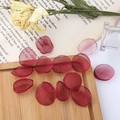 Detailed view of dark red tulle flower petals for DIY jewelry on a vintage wood tray - Burgundy