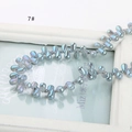 Macro shot of iridescent light blue teardrop beads on a vintage frame for DIY jewelry - Teal