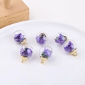 Detail view of six glass bubble pendants filled with real purple dried flowers and gold caps - Deep purple