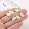 Detail of six light green teardrop crystal pendants held by hand for DIY jewelry making - Retro Green