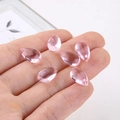 Macro shot of six pink teardrop glass charms held in hand for jewelry making and DIY crafts - Transparent Pink