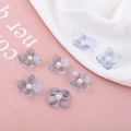 Detail van DIY transparante acryl bloembedeltjes met paarse nerven en witte parels - Lichtblauwe vierbladige bloem
