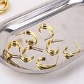 Detalle de pendientes dobles en forma de C dorada en una bandeja de acero inox - Pendientes de Botón C de Doble Capa (1#)