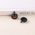 Detailed view of matte black Halloween pumpkin charms with orange Jack-o'-lantern smile - Black Pumpkin